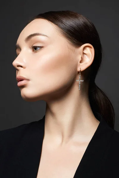 Beautiful young woman with jewelry earrings. pretty brunette girls portrait