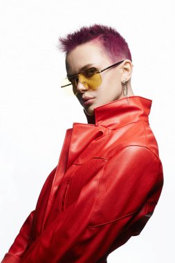 Boyalı kısa saçlı ve sarı gözlüklü genç bir kadın. Mücevher ve kırmızı deri ceketli güzel seksi manken kız. Pembe Saç Tarzı