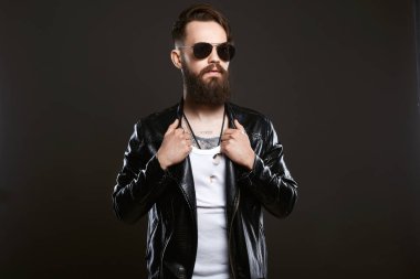 tattooed handsome man in sunglasses and leather coat. Brutal bearded Sexy boy