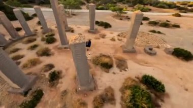 Dynamic fpv drone flying around Time and Space spot, with the DJ playing in the center, sunrise vibes in Cala Llentia, Ibiza. July 2022. High quality 4k footage