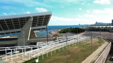 Aerial forward shot of a port and city at day time, solar panel at port and city view. Forum port, Barcelona, Spain. 27 August 2022. Great natural light with amazing colors in a summer. High quality 4k footage