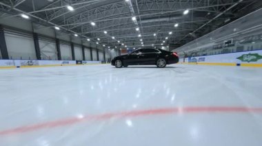Buz hokeyi sahasında sürüklenen siyah arabanın fpv drone görüntüsü. Hava Aracı Yüksek Açı İzleme Çekimi. Yüksek kalite 4k görüntü