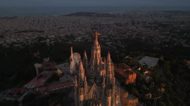Gün batımında Sagrat Cor tapınağıyla Barcelona 'nın gökyüzü manzarası. Tibidabo Dağı. Katalonya, İspanya. Yüksek kalite 4k görüntü
