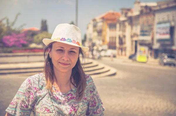 Mujer joven viajera con sombrero mirando a la cámara posando y sonriendo en las calles de la ciudad de Aveiro en Portugal — Foto de Stock