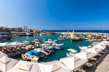 Kyrenia Girne kasabasında yatları olan eski marina limanı ve limanından gelen Panoramik manzaranın suluboya çizimi mavi gökyüzü ve dağlara karşı, Kuzey Kıbrıs