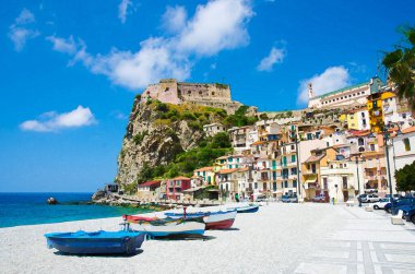 Kumlu kumsalda renkli balıkçı teknelerinin suluboya çizimi. Tyrhenian deniz kıyıları Scilla sahil kenti. Geleneksel evleri ve eski ortaçağ şatosu olan Castello Ruffo, Calabria, İtalya.