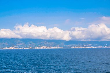 Messina Boğazı 'nın suluboya çizimi Akdeniz ve Tyrhenian denizi ile Sicilya adasını birleştirdi mavi gökyüzü beyaz bulutları ile, Güney İtalya' daki Reggio di Calabria limanından manzara