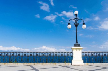 Rıhtıma bakan Lungomare Falcomata rıhtımı, Messina Boğazı ve Sicilya adası arka planı, Reggio di Calabria, Güney İtalya