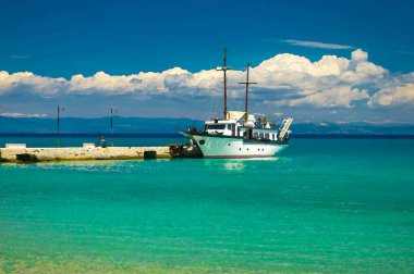 Toroneos kolpos körfezinin mavi cennet suyundaki tekne manzarasının suluboya çizimi, Sithonia yarımadası üzerindeki mavi gökyüzü beyaz bulutları Pefkohori, Halkidiki, Makedonya, Yunanistan 'daki iskele iskelesi yakınlarında