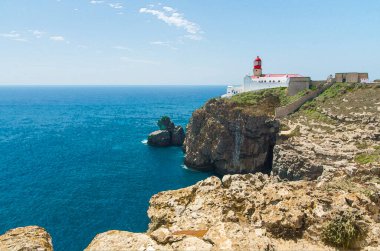 Algarve 'deki Atlantik Okyanusu' nun mavi suyuyla Cape St. Vincent 'in suluboya resimleri, Moher ve Atlantik Okyanusu' nun uçurumları, Portekiz 'deki Sagres yakınlarında beyaz kırmızı deniz feneri.
