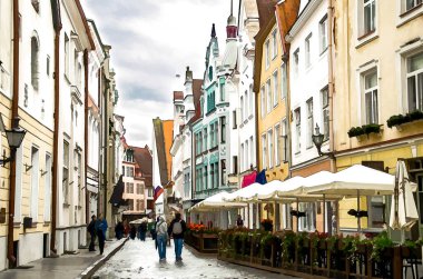 Tallinn 'in Eski Kasabası' nın suluboya resimleri güzel renkli binalar ve yürüyen insanlar, Estonya
