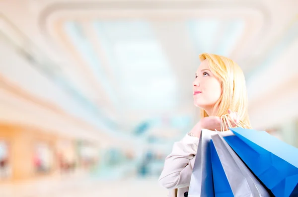 sarışın genç kadın alışveriş torbaları yukarı doğru seyir tasarlamak holding