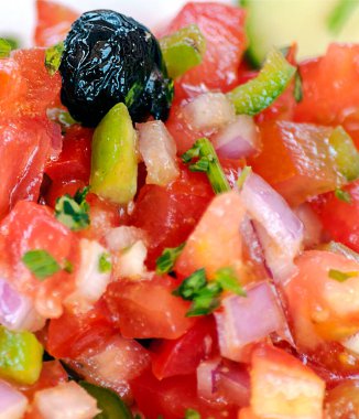 Arka plan oluşturan bir tabakta servis edilen domates salatası