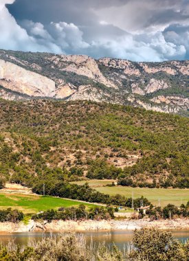 İspanya 'nın kuzeyinde ekilmiş tarlalar ve bulutlu bir günde arka planda dağlar..