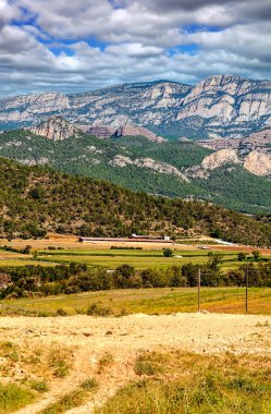İspanya 'nın kuzeyinde ekilmiş tarlalar ve bulutlu bir günde arka planda dağlar..