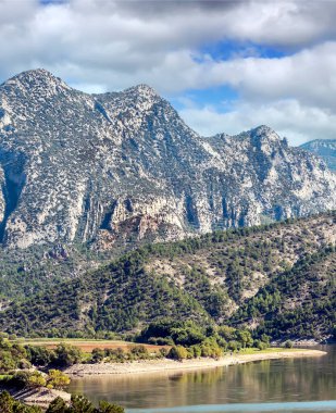 İspanya 'nın kuzeyinde ekilmiş tarlalar ve bulutlu bir günde arka planda dağlar..