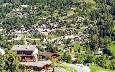 Bulutlu bir günde, Saint Luc vadisindeki İsviçre Alplerinde ahşap evler.
