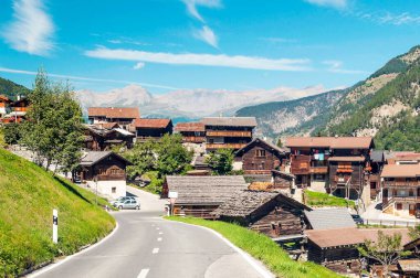 Bulutlu bir günde, Saint Luc vadisindeki İsviçre Alplerinde ahşap evler.