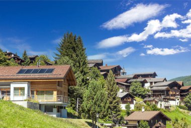 Bulutlu bir günde, Saint Luc vadisindeki İsviçre Alplerinde ahşap evler.