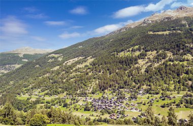Bulutlu bir günde, Saint Luc vadisindeki İsviçre Alplerinde ahşap evler.