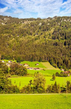 Bulutlu bir günde ahşap kulübeleri ve çayırları olan İsviçre Alpleri Dağları.