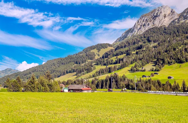 Bulutlu bir günde ahşap kulübeleri ve çayırları olan İsviçre Alpleri Dağları.