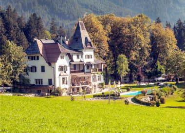 Bulutlu bir günde, Avusturya Alplerinde tahta evleri olan Gosau köyü..