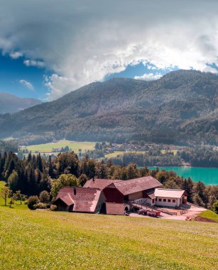 Bulutlu bir günde, Avusturya Alplerinde tahta evleri olan Gosau köyü..