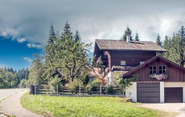 Bulutlu bir günde, Avusturya Alplerinde tahta evleri olan Gosau köyü..