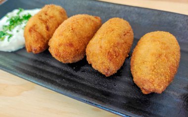 Tabakta servis edilen soslu kroket.