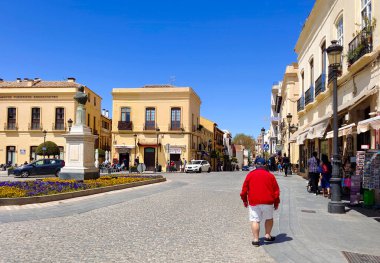 RONDA İSPA - Mayıs 2022. Güneşli bir günde Ronda 'nın alışveriş caddesinde bir turist. Malaga 'nın bir köyünde yürüyen insanları görebilirsiniz..