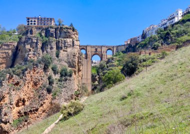 Güneşli bir günde İspanya 'nın güneyindeki Ronda Köprüsü. Dağların tepesinde bir kasaba