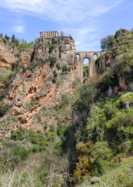 Güneşli bir günde İspanya 'nın güneyindeki Ronda Köprüsü. Dağların tepesinde bir kasaba