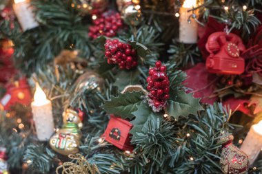 Noel ağacının süslediği kırmızı meyvelerin yakın çekimi.