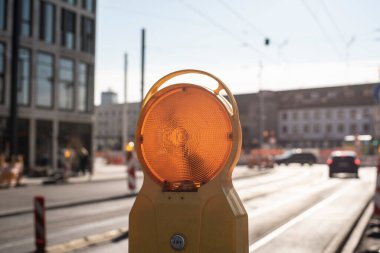 Şehir caddesinde yansıtıcısı olan sarı bir uyarı işareti.