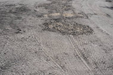 Onarım sürecinde değirmenli yüzeyi olan hasarlı bir yol.