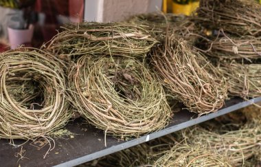 Çıplak dallardan oluşan yuvarlak çelenkler bir rafta satılıktır.