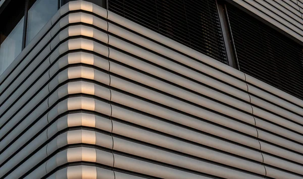 Akşam güneşi bir ofis binasının metal cephesinde parlıyor.