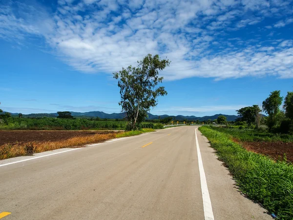 Estrada de asfalto com céu azul — Fotografia de Stock