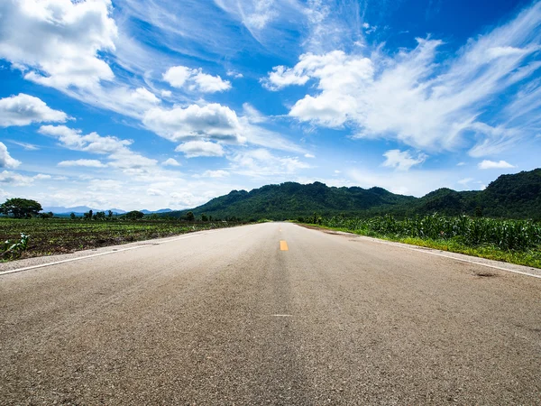 Droga asfaltowa z niebieskim niebem — Zdjęcie stockowe