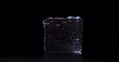 Kapalı arkaplanda dönen buz küpleri.