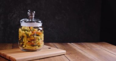 Tahta masada kavanozda kurutulmuş makarna. Dolly vurdu..