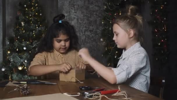Dzieci pakują razem prezenty świąteczne.. — Wideo stockowe