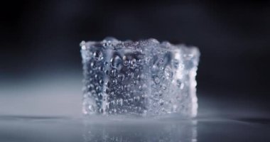 Kapalı arkaplanda dönen dumanlı buz küpleri.