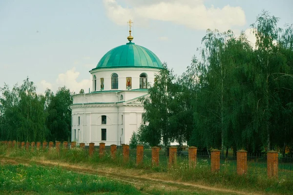 Yeşil kubbeli Aziz Niklas 'ın beyaz tapınağı. Beyaz güzel kilise ağaçların ve bulutların arasında.