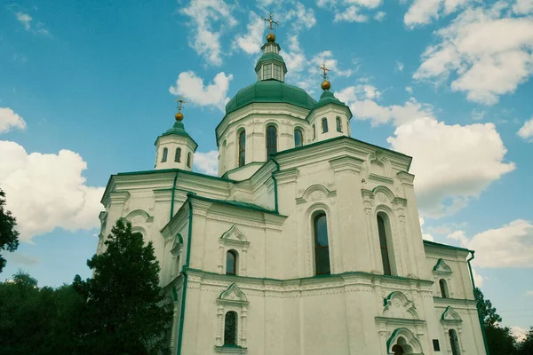 Yeşil kubbeli Aziz Niklas 'ın beyaz tapınağı. Beyaz güzel kilise ağaçların ve bulutların arasında.