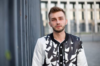 Beyaz ve siyah takım elbiseli yakışıklı bir adam ve üzgün, şaşkın bir bakış. Kirli sakallı, şık takım elbiseli ve baştan çıkarıcı görünüşlü bir adam..