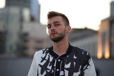 Beyaz ve siyah takım elbiseli yakışıklı bir adam ve üzgün, şaşkın bir bakış. Kirli sakallı, şık takım elbiseli ve baştan çıkarıcı görünüşlü bir adam..