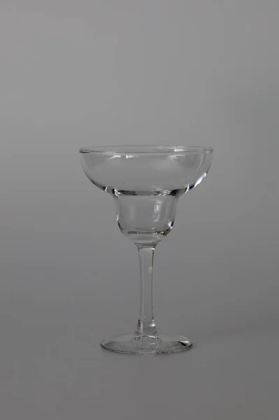 Transparent glass for cocktails on a white background. Glass for tequila, margarita, pina colada and other cocktails. Transparent cocktail glass for bar