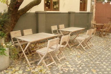 Kafenin yanındaki sandalyeli güzel ahşap masa. Açık ahşap masa ve bahçede sandalyeler. Teras, fotojenik masa ve sandalyeler.